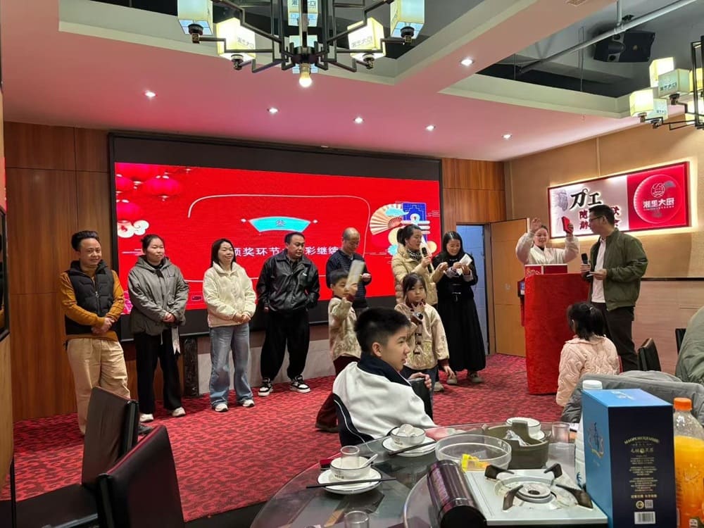 Shenzhen Qixingyuan CEO Mr. Zhao presenting red packs to the families of workers during the company's annual meeting as a gesture of appreciation